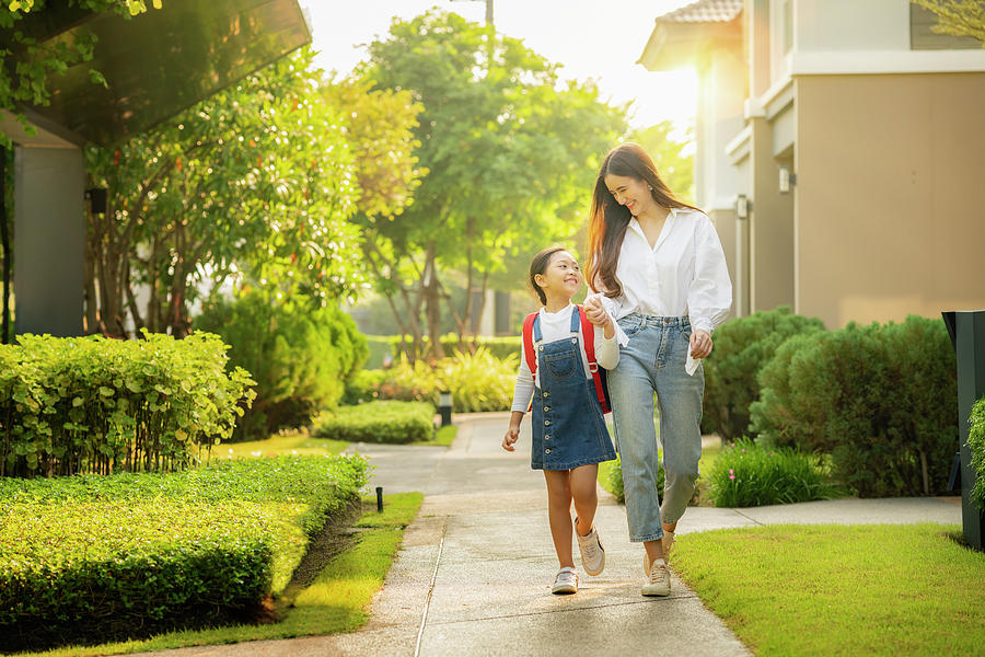 Asian preschool girl walks with her mother to go to school