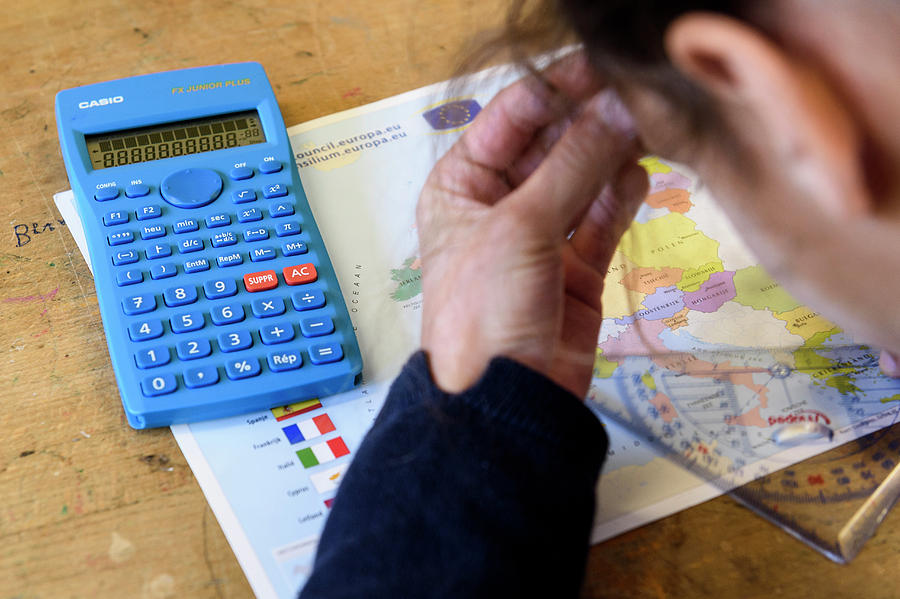 A student with a calculator, map and protractor.